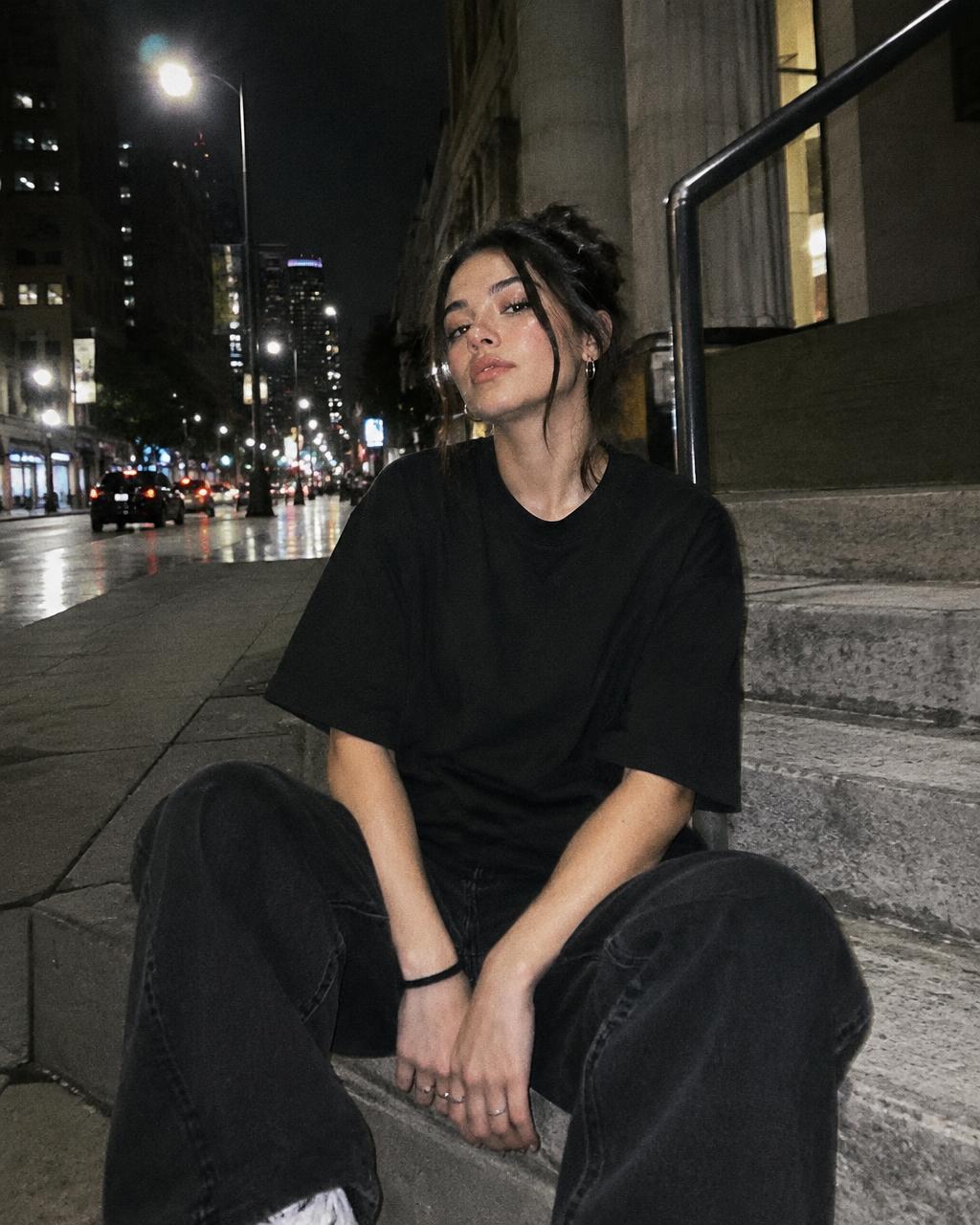 Modèle assise sur des marches en t-shirt noir